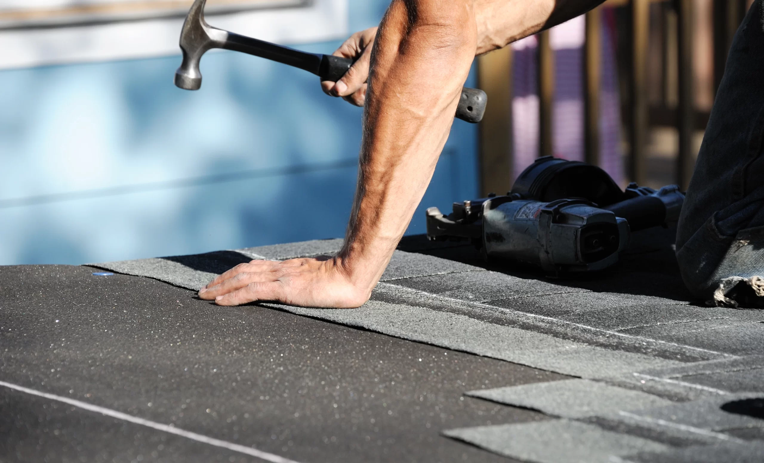 close-up-of-roofer-hammering-on-roof-scaled