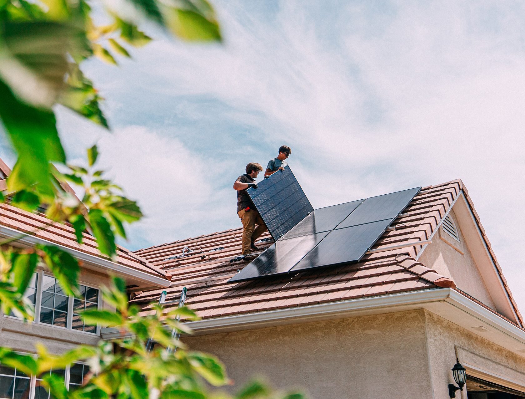 homeowners-installing-solar-panels-on-suburaban-home