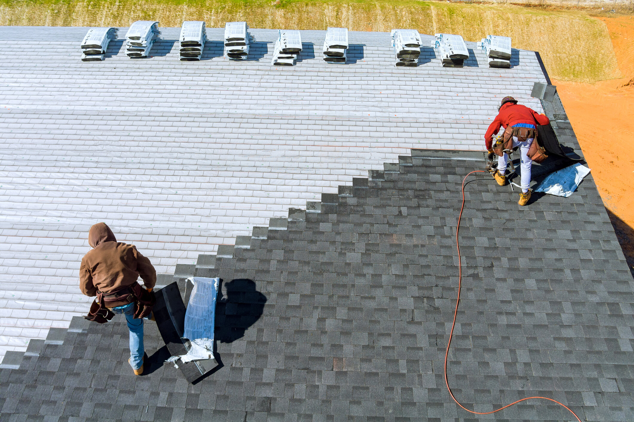 worker-hands-installing-bitumen-roof-shingles