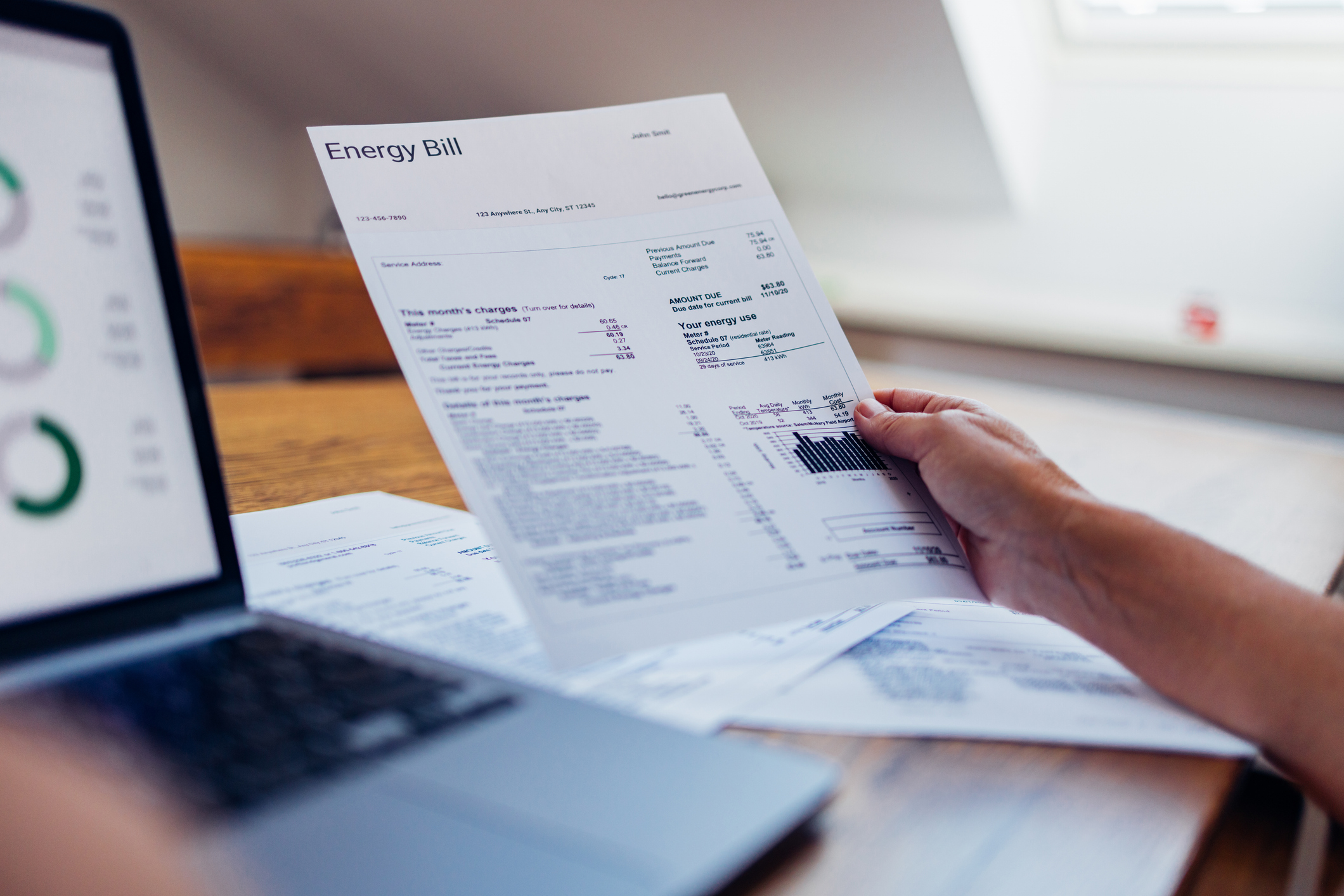 person-reviewing-energy-bill-on-a-laptop